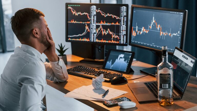 Hombre angustiado frente al ordenador por su adicción a los bitcoins.