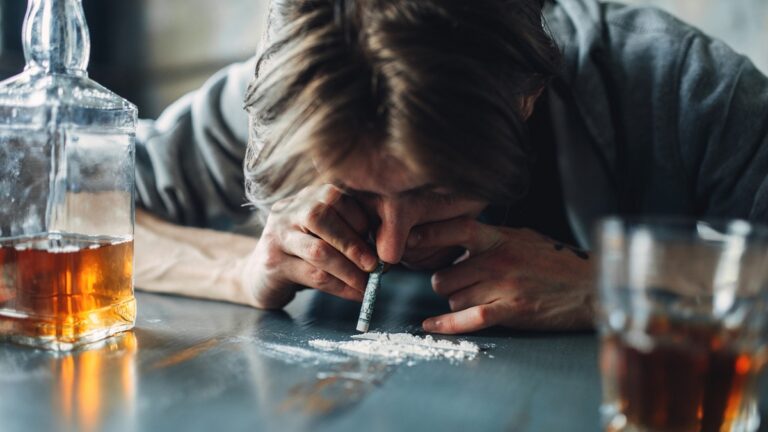 Un hombre consumiendo alcohol y cocaína.