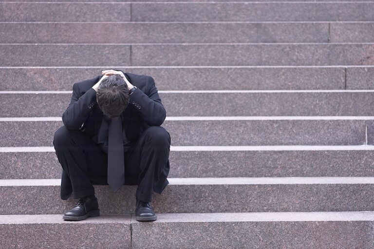 Una persona con adicciones sentado en una escalera