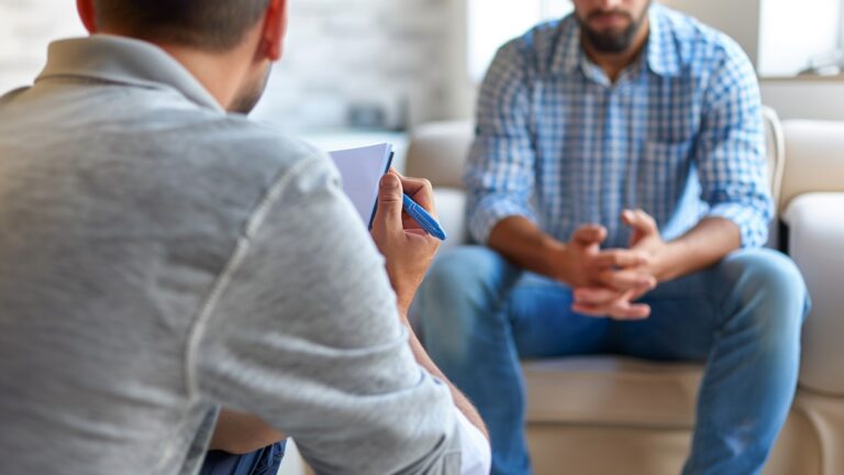 una persona con adicción al alcohol recibiendo tratamiento psicológico